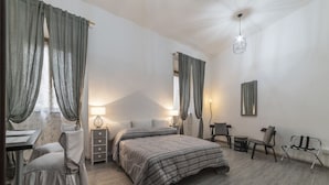 Une chambre à coucher avec un lit, des tables de chevet, un bureau et une chaise.