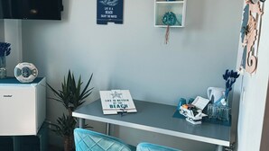 A small, modern room with a desk, two chairs, a wall-mounted shelf, and a few decorative items. - ORCA Hotel am Elbschloss (Dresden)