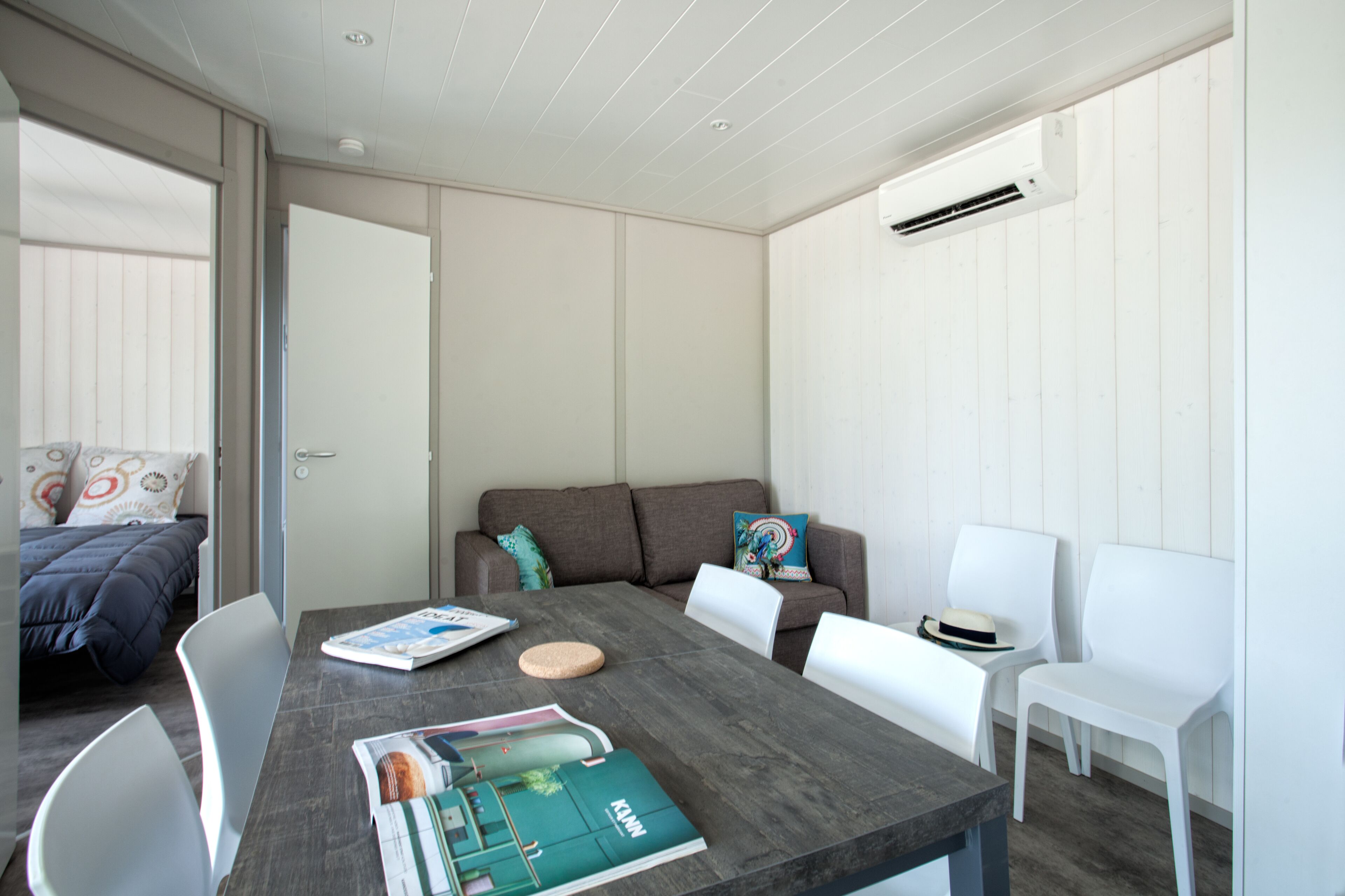 Une chambre moderne comprenant une table à manger, des chaises, un canapé et un lit.