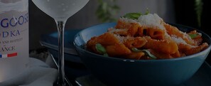 A bowl of pasta with a bottle of gooseberry liqueur and a martini glass. - VISIONAPARTMENTS Zurich Bellariastrasse (Zürich)