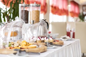 A buffet table with various food items and a coffee machine.