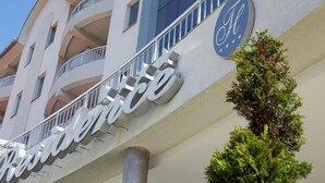 Un hotel con un llamativo letrero que dice 'Resort', un diseño arquitectónico moderno y un balcón visible.