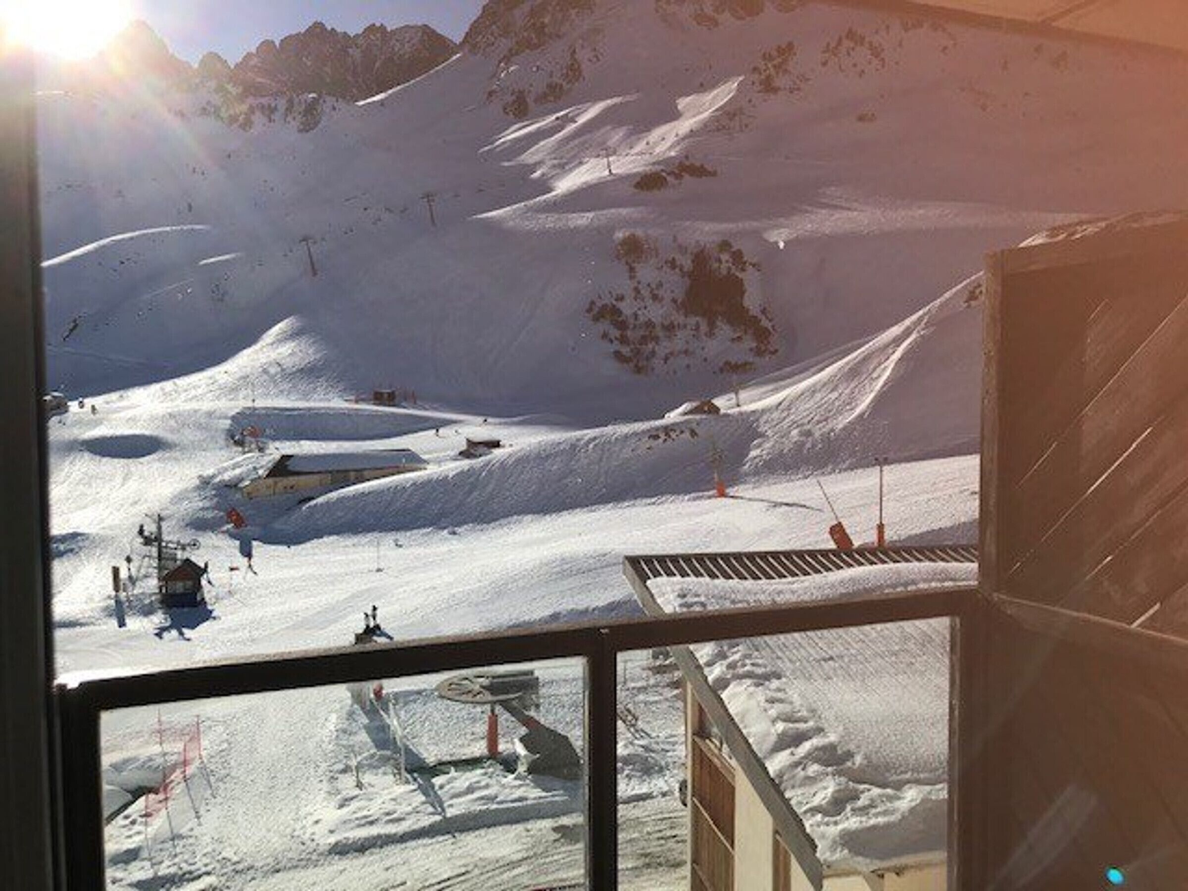 A snow-covered ski slope with a chairlift and a building in the foreground.