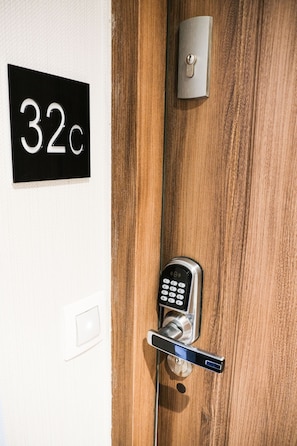 A door with a numeric keypad lock, a keyhole, and a doorbell.