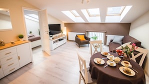 A modern apartment with a dining area, a sofa, and a TV. - Old Town Vistula Premium Apartments (Kraków)