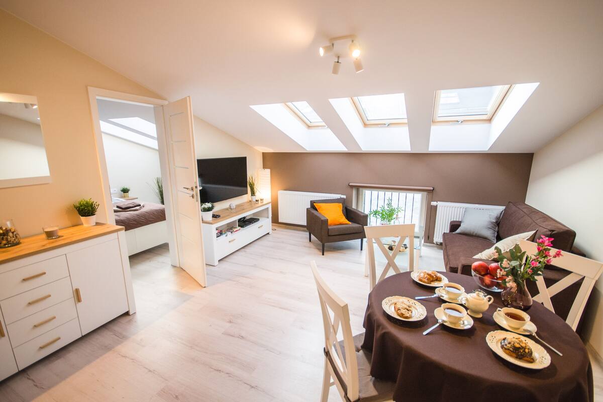 Un appartement moderne comprenant un coin repas, un canapé et un téléviseur.