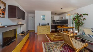 A modern living space with a kitchen, dining area, and a cozy seating area. - Apartment Maro (Crikvenica)