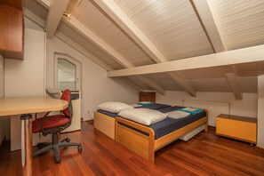 A bedroom with a wooden bed, a desk, and a chair.