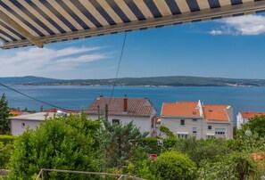A coastal view with houses, a clear sky, and a distant coastline.