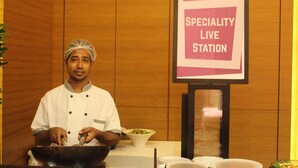 A chef at a kitchen station with a sign for a "Specialty Live Station" at the German Palace Vinca. - Hotel German Palace (Gandhinagar)