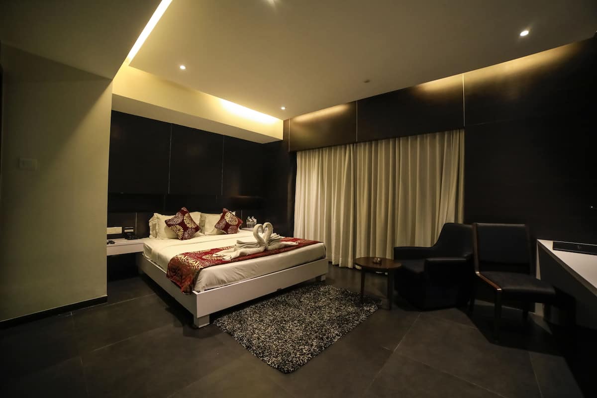 Una habitación de hotel moderna con una cama grande, un escritorio y una silla.