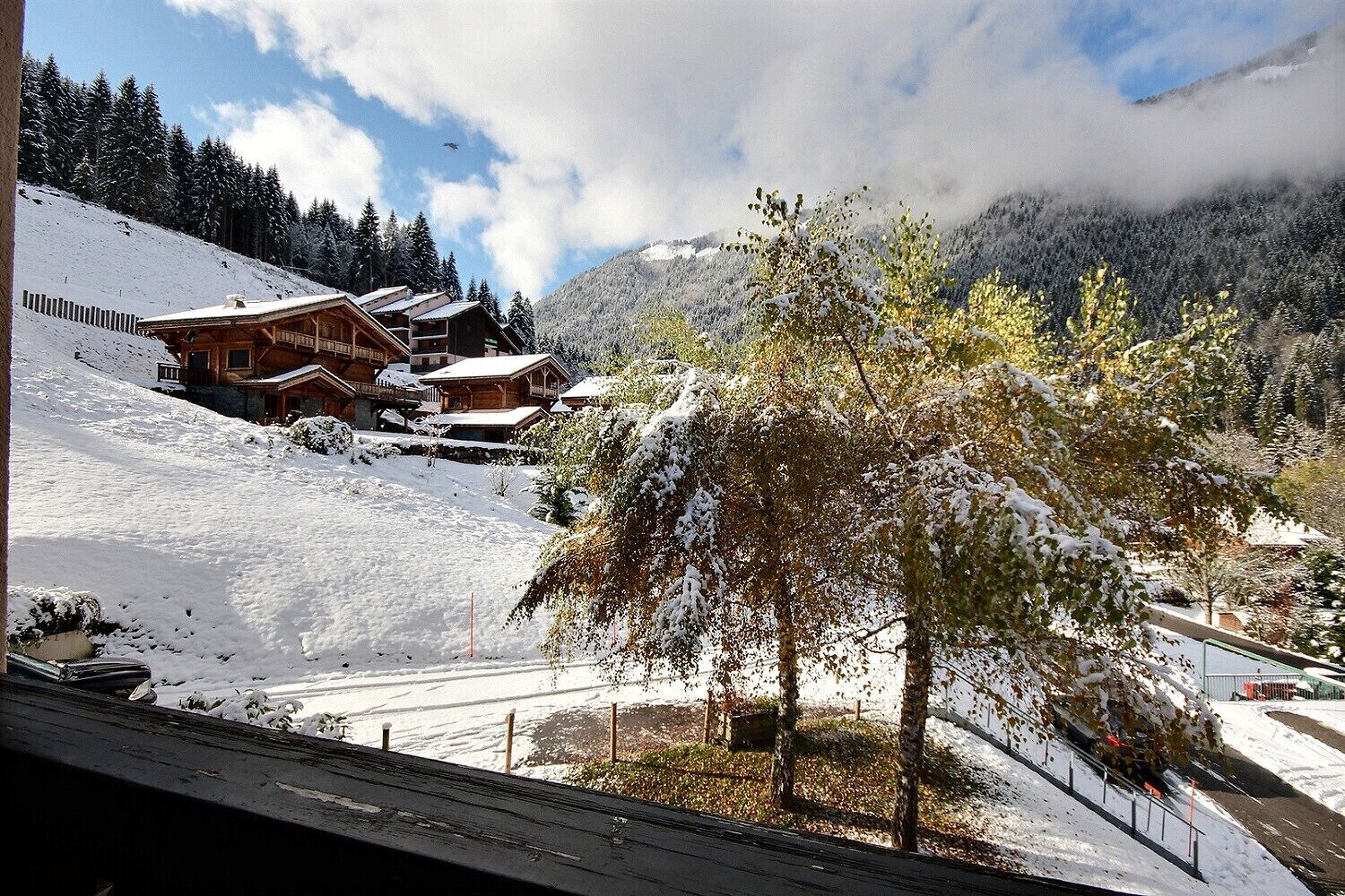 Een met sneeuw bedekte berg met houten chalets en een skilift.