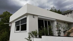 A modern white building with a flat roof, large windows, and a satellite dish. - Holiday House Linda (Crikvenica)