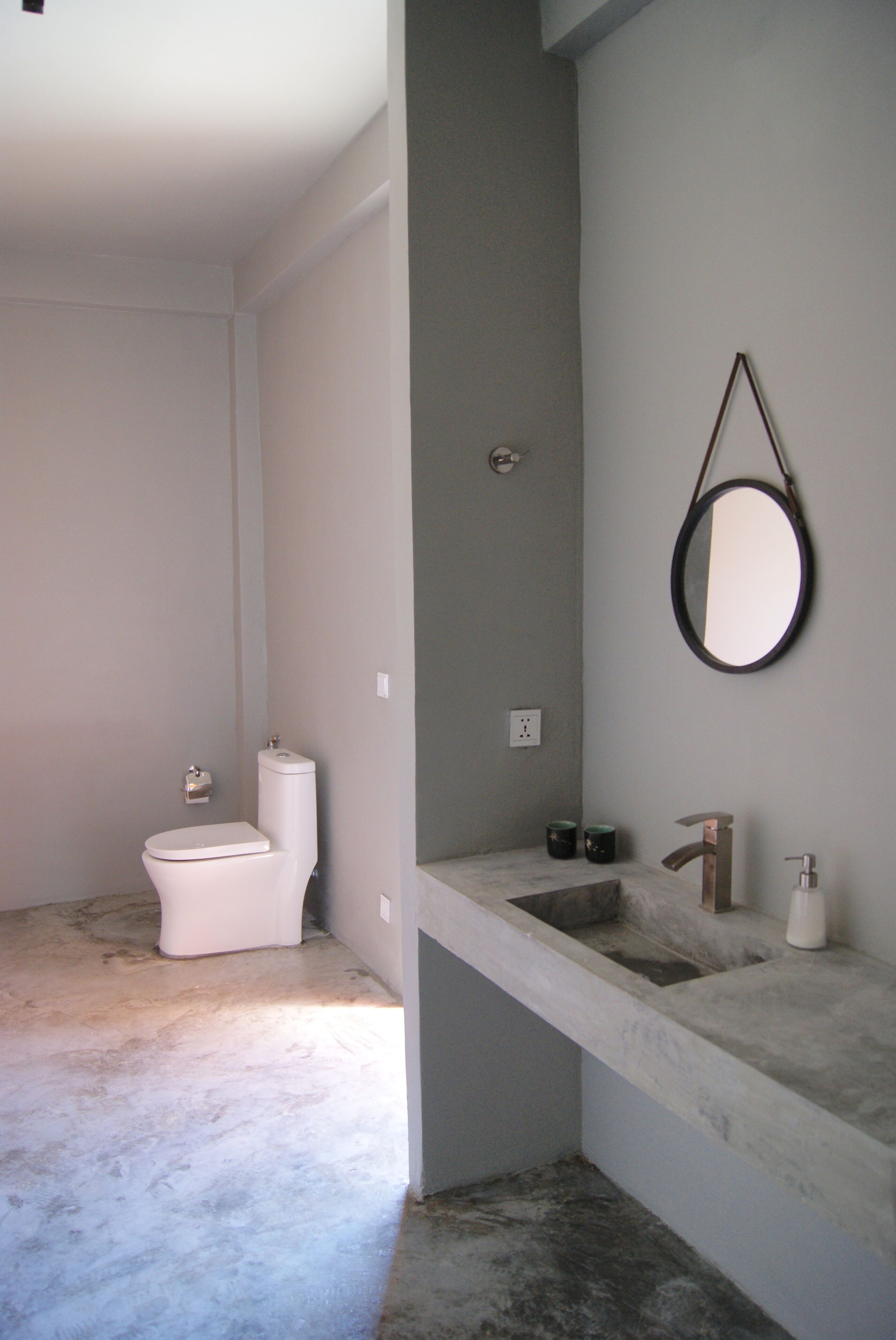 A bathroom with a toilet, sink, and mirror.