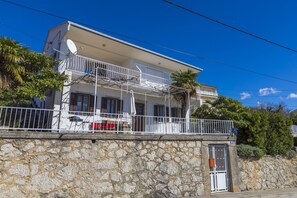 A two-story building with a balcony, stone wall, and a gate. - Apartment Heidy (Crikvenica)