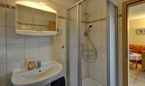 A bathroom with a sink, mirror, and shower. - Inselblume 41 - 42 (Fehmarn)