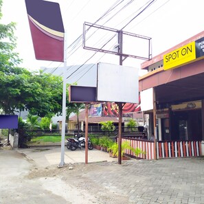 A hotel with a sign reading "SPOT ON" and a large blank billboard. - Hotel O Pondok Ripuji (Makassar)