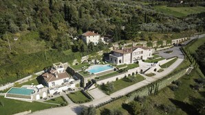An aerial view of a large estate with multiple buildings, a swimming pool, and well-maintained gardens. - Villa Caiano (Londa)