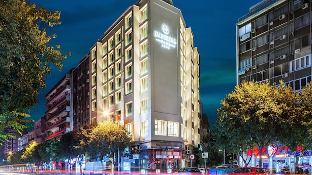 Un hotel de varios pisos con un letrero llamativo que dice "IMPERIAL PLACE HOTEL".