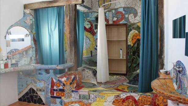 A bathroom with a mosaic floor, a wooden shelf, and a sink with a tiled backsplash. - TEGUISE OLD HELMET (Teguise)
