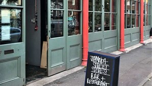 Liiketila, jonka edessä on kyltti, jossa kerrotaan, että siellä on jamaikalainen katukauppa, baari ja ravintola.
