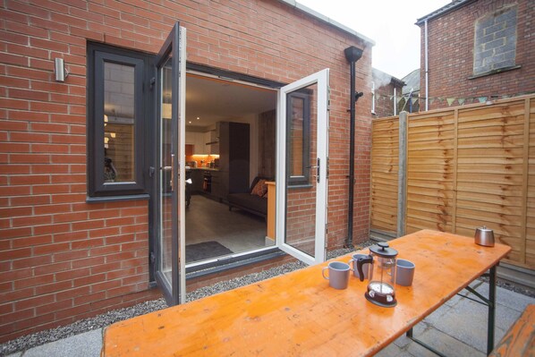 A brick house with a wooden table and a door leading to a living room.