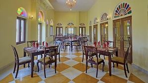 A dining area with checkered flooring, wooden tables, and chairs.