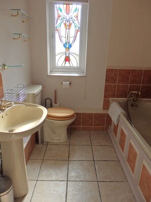 A bathroom with a toilet, sink, and bathtub. - Rosehip Cottage (Somerton)