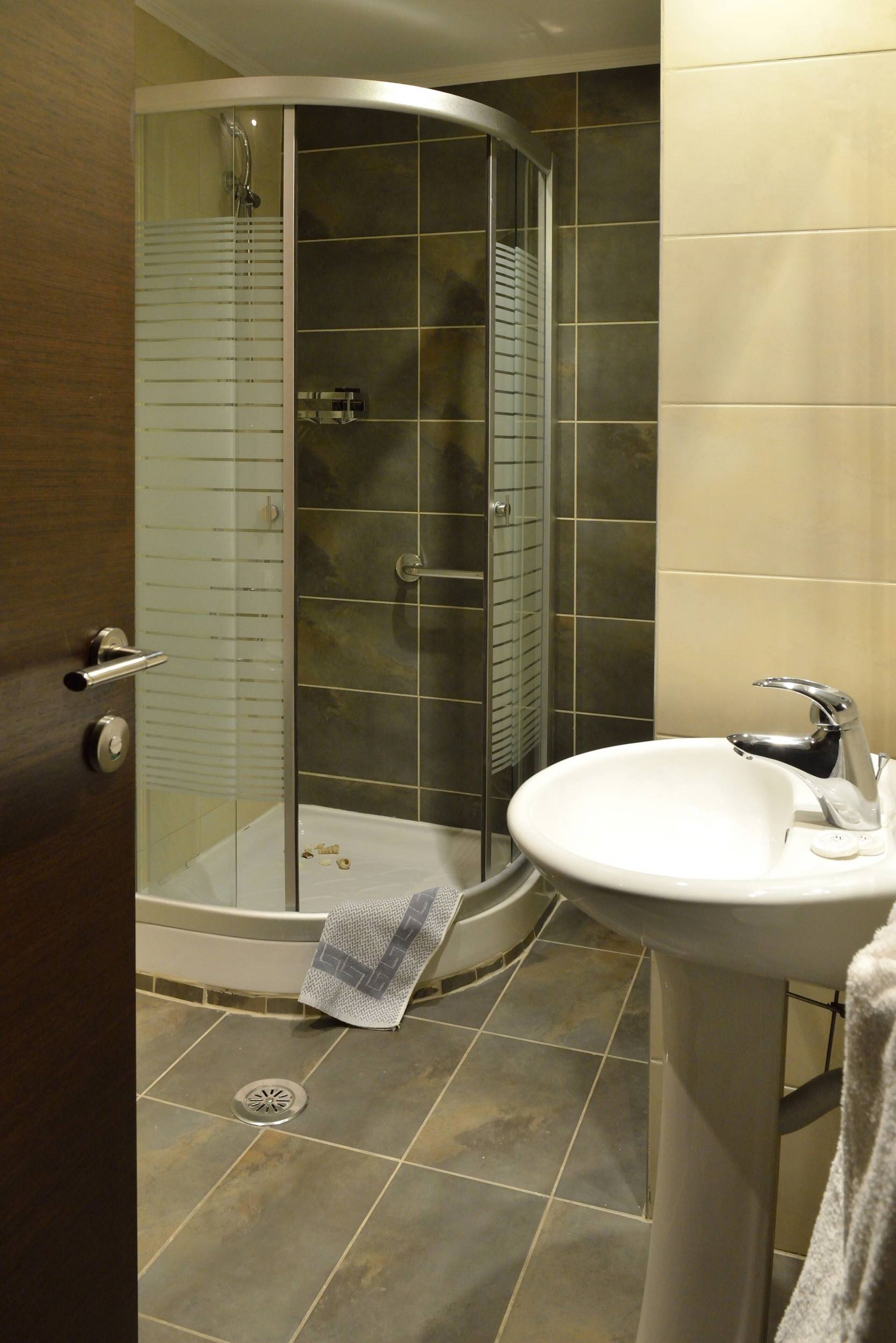 Ein Badezimmer mit Duschkabine, Waschbecken und Handtuchhalter.