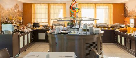 A buffet setup with a central island, serving area, and dining tables.