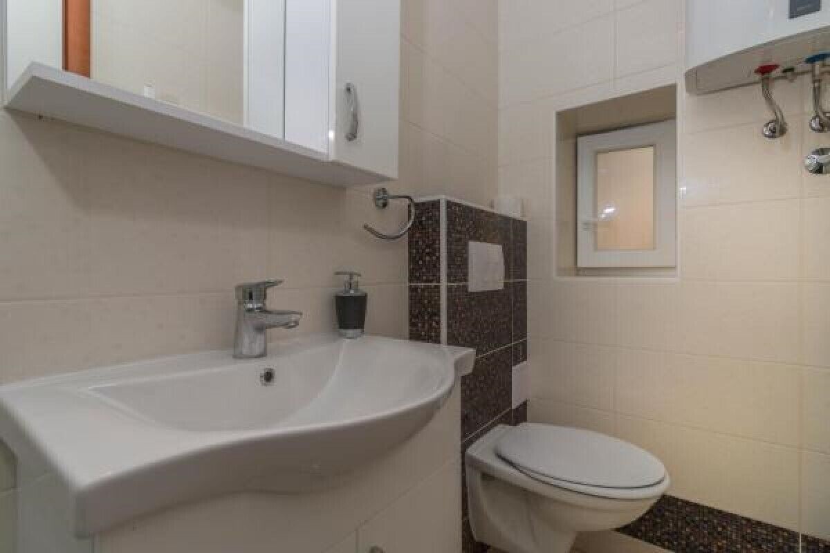 Ein Badezimmer mit Waschbecken, Toilette und Duschbereich.