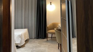 A hotel room with a bed, a chair, a desk, and a wardrobe. - Orya Apart (Bodrum)