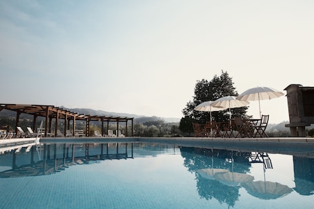Una piscina al aire libre, sombrillas