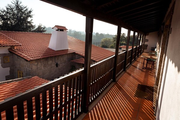 Un balcón techado con vistas a un edificio de tejas rojas.
