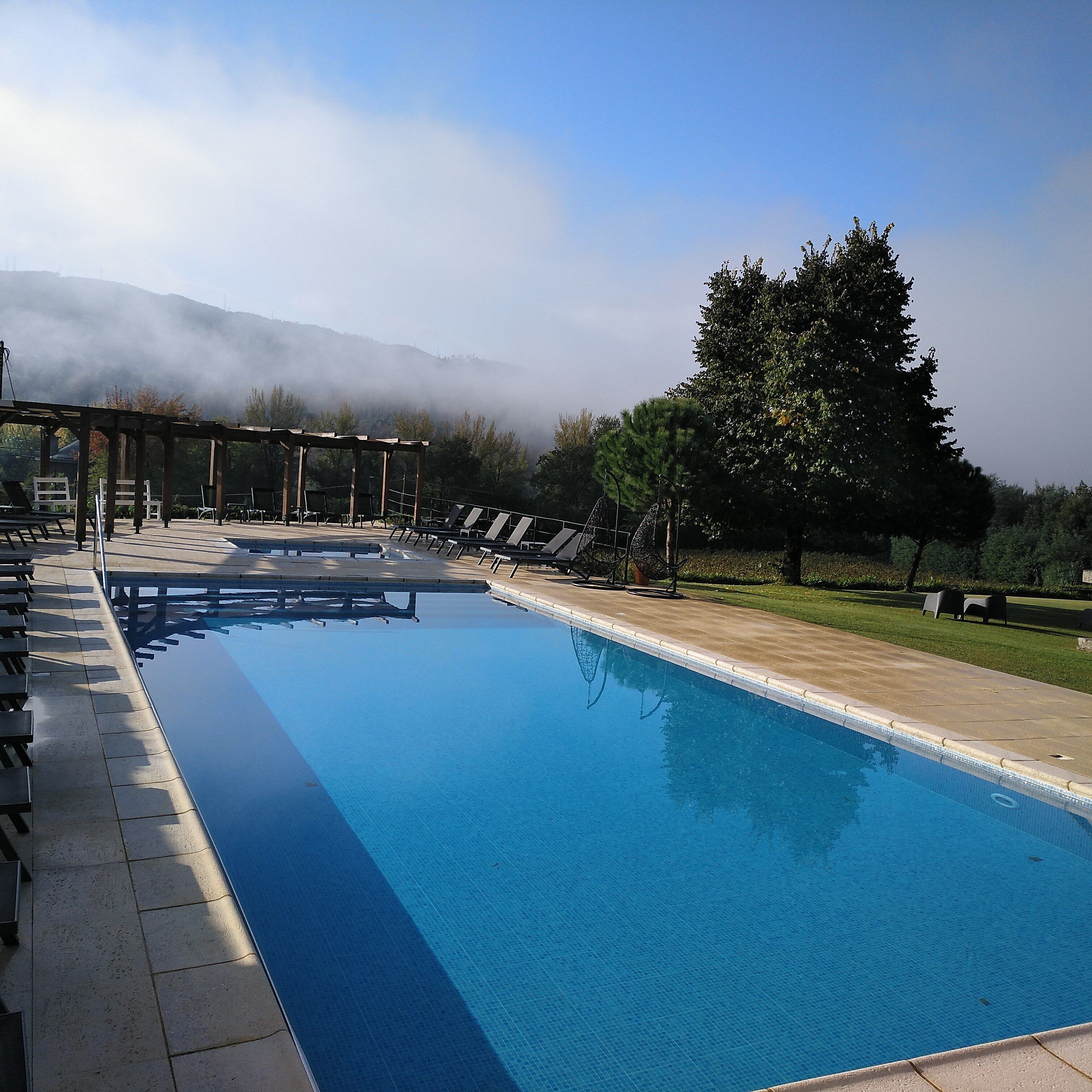 Una piscina al aire libre, sombrillas