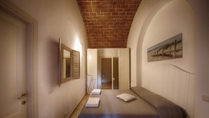Une chambre d’hôtel avec un lit, un miroir, un tableau et une porte.