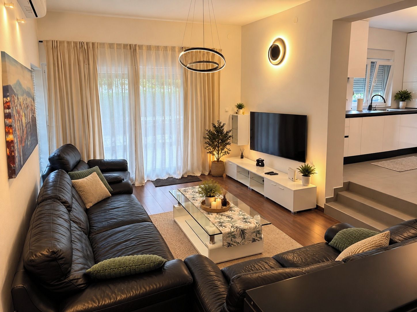 Ein modernes Wohnzimmer mit einer Ledersofa, einem Couchtisch und einem Flachbildfernseher.