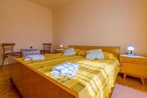 Une chambre à coucher avec un lit en bois, deux tables de chevet, une chaise et une petite table.