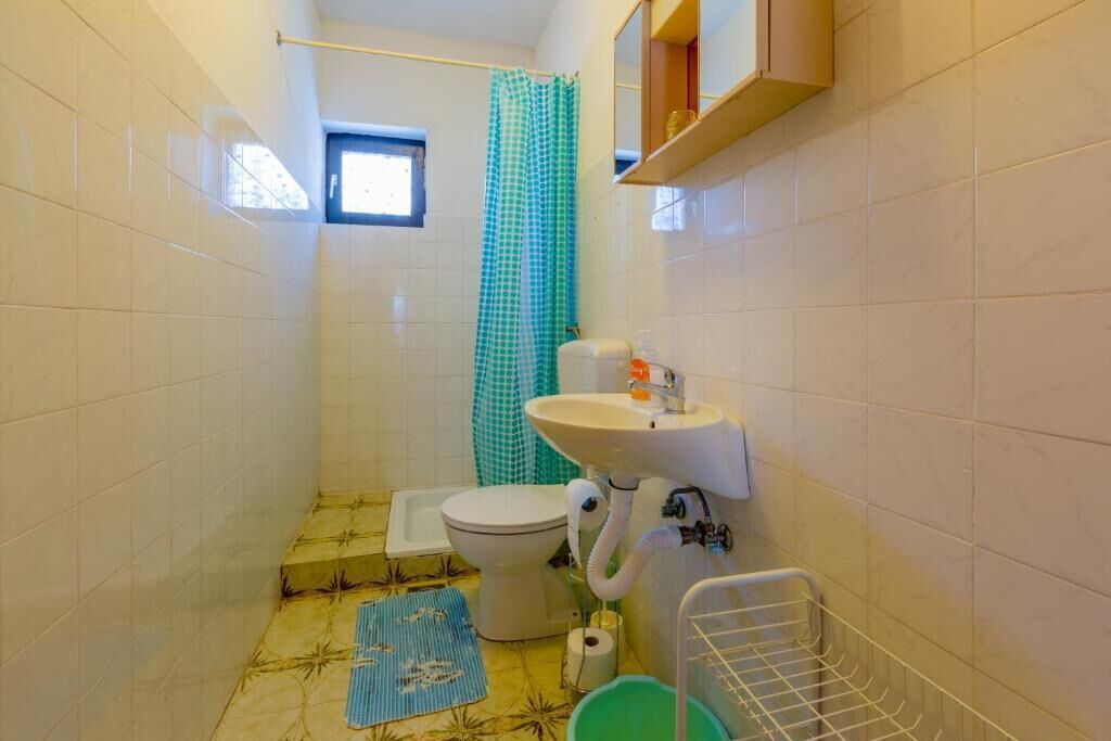 A small bathroom with a toilet, sink, and shower curtain.