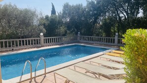 A rectangular swimming pool with a white balustrade, surrounded by trees and a clear sky. - Ref. Nav51 -  (Rosas / Roses)