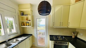 A kitchen with a gas stove, a sink, and a window.