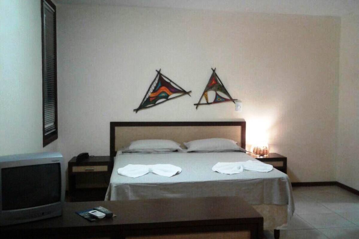 Une chambre d’hôtel avec un lit, une table de chevet, une lampe et un tableau au mur.