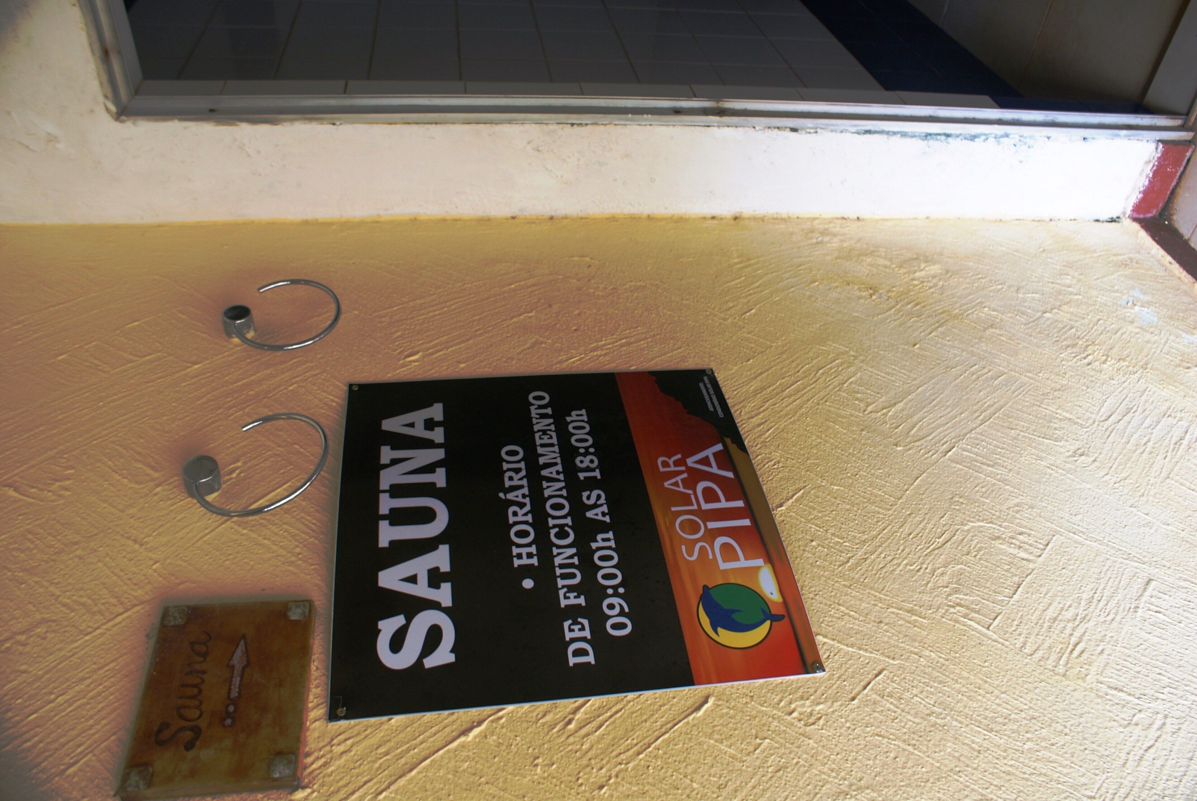 Señal de un sauna con horario de atención y un logotipo.