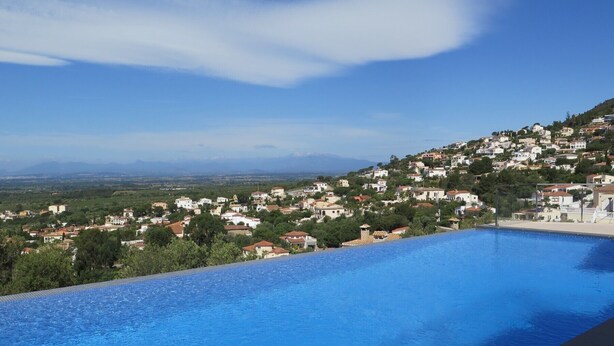 Una piscina con vista su una cittadina collinare.