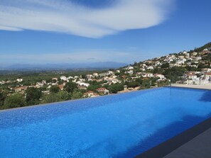 A swimming pool with a view of a hillside town.