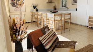 A modern kitchen with a central island, wooden chairs, and pendant lighting. - Ref. Leo06 -  (Rosas / Roses)