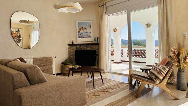 A living room with a sofa, armchair, TV, and a fireplace. - Ref. Leo06 -  (Rosas / Roses)