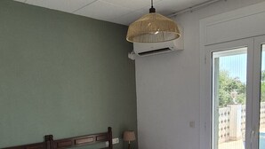 Ein Zimmer mit zwei Betten, einem Deckenventilator und Blick ins Freie.