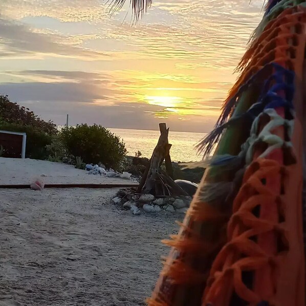 A sunset view with a wooden structure and a beach. - Serenity On The Bay2 - Two Bed Cayman Brac - Airport Shops Restaurants Close! (Cayman Brac)