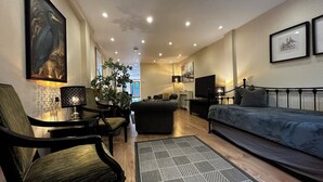 Uma sala de estar moderna com sofá, poltrona, televisão e objetos decorativos.